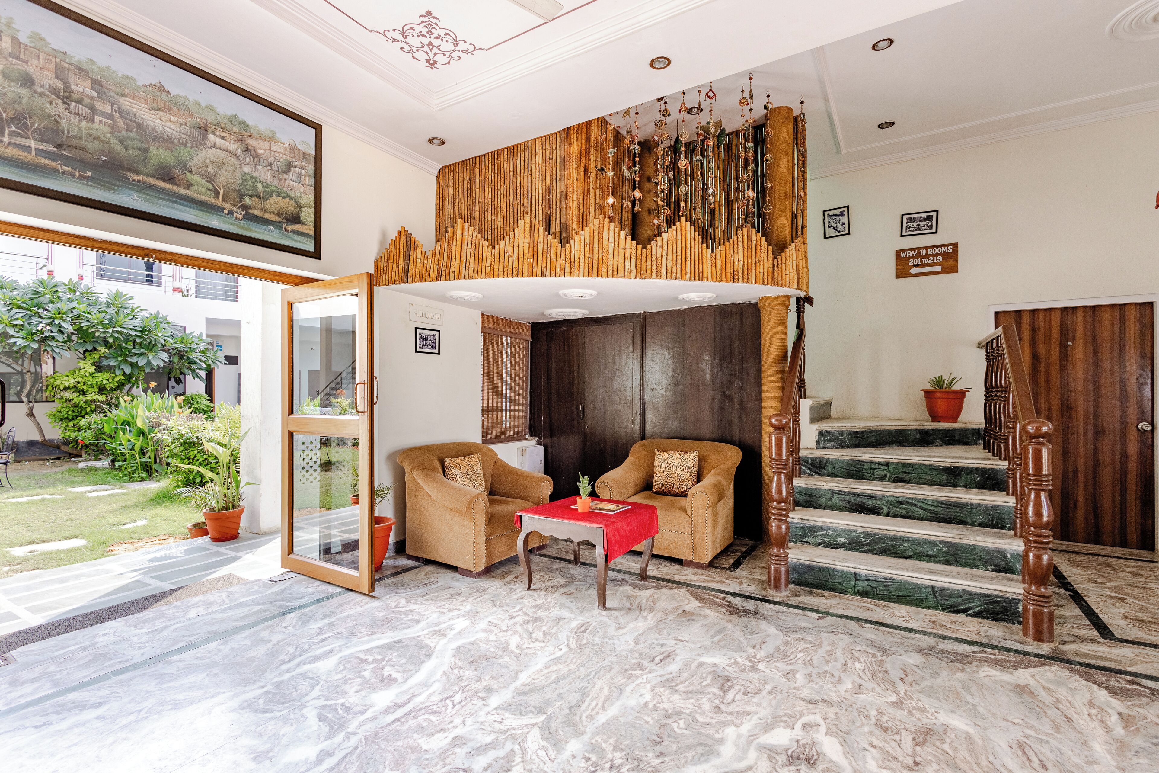 A spacious living area with a large window, a wooden staircase, and a view of the outdoors.