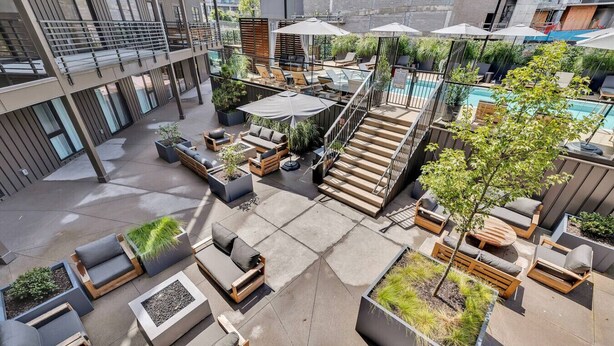A rooftop patio with outdoor seating, a pool, and a staircase. - The Speakeasy- Walk to Broadway! Pool, Gym, Parking & More, Amazing Location (Nashville)