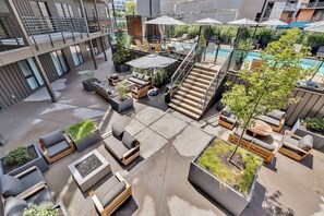 A rooftop patio with outdoor seating, a pool, and a staircase. - The Speakeasy- Walk to Broadway! Pool, Gym, Parking & More, Amazing Location (Nashville)
