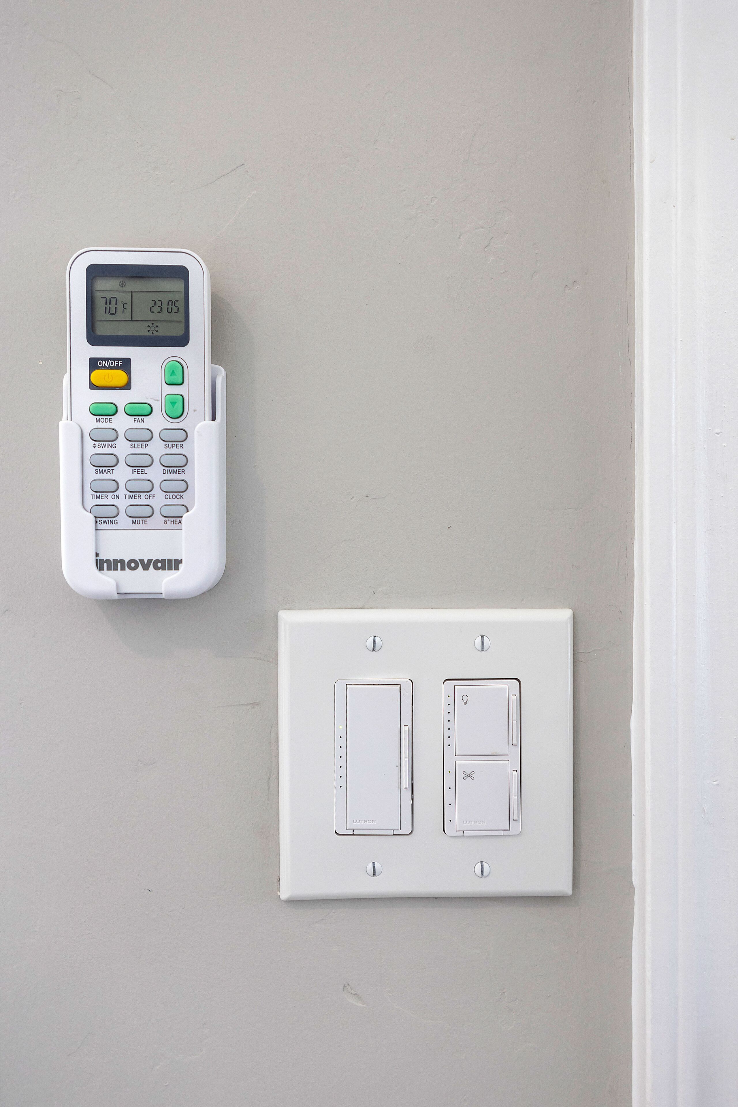 A control panel with a digital display and a wall-mounted switchboard.