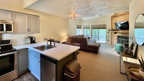 A modern kitchen with a central island, built-in appliances, and a dining area with a view. - Updated Condo | Walk to Pool & A/C (Somerset)