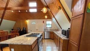 Una cocina con armarios de madera, encimera de granito, estufa de acero inoxidable y lavavajillas.