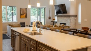 A modern kitchen with a large island, built-in appliances, and pendant lighting.