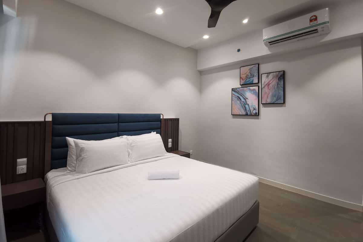 Habitació d'hotel moderna amb un llit, un ventilador de sostre, un aparell d'aire condicionat i una obra d'art abstracta a la paret.