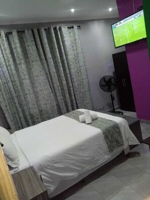 Desk, laptop workspace, iron/ironing board, bed sheets