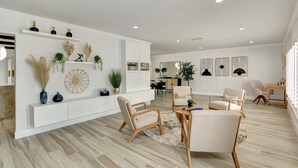 A modern living room with a white console table, beige chairs, and a round coffee table. - Riviera Oasis: Waterfront, Pool, 5min To Beach (Fort Lauderdale)