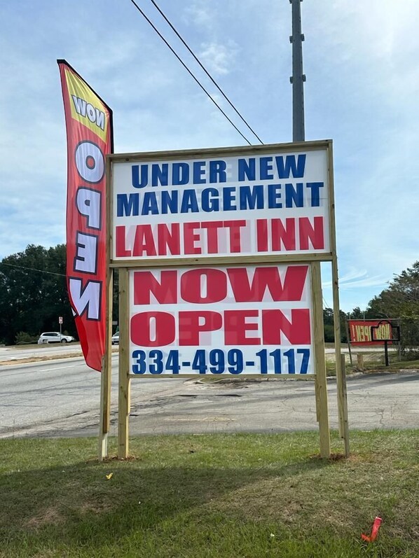 A sign for the Lanett Inn advertising new management and its opening.