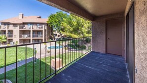 A balcony with a view of a swimming pool and a building with multiple balconies. - Sports Village Resort #Z9 | Affordable Getaway (Saint George)