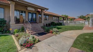 A building with a sign reading 'Sports Village Clubhouse' and a staircase leading to the entrance. - Sports Village Resort #Z9 | Affordable Getaway (Saint George)