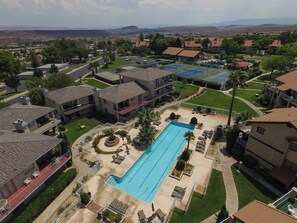 Zona residencial com piscina, vários edifícios e vista para montanhas distantes.