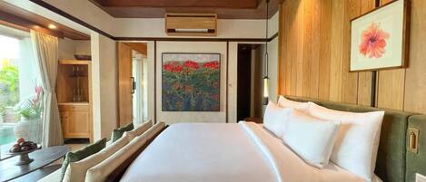 Habitación de hotel con una cama grande, techo de madera, un cuadro y vistas al exterior.