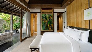 A modern bedroom with a large bed, a wooden ceiling, and a view of a garden. - The Ridge Bali (Ubud)