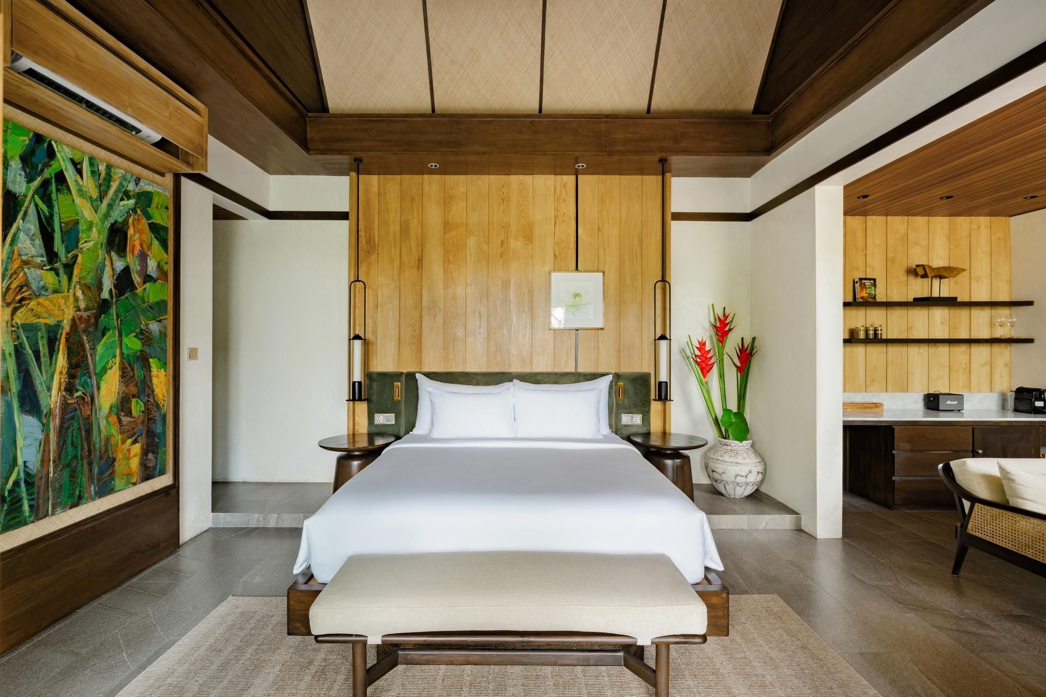 Un dormitorio moderno con una cama grande, mesitas de noche, un cuadro y vistas a una zona de cocina.
