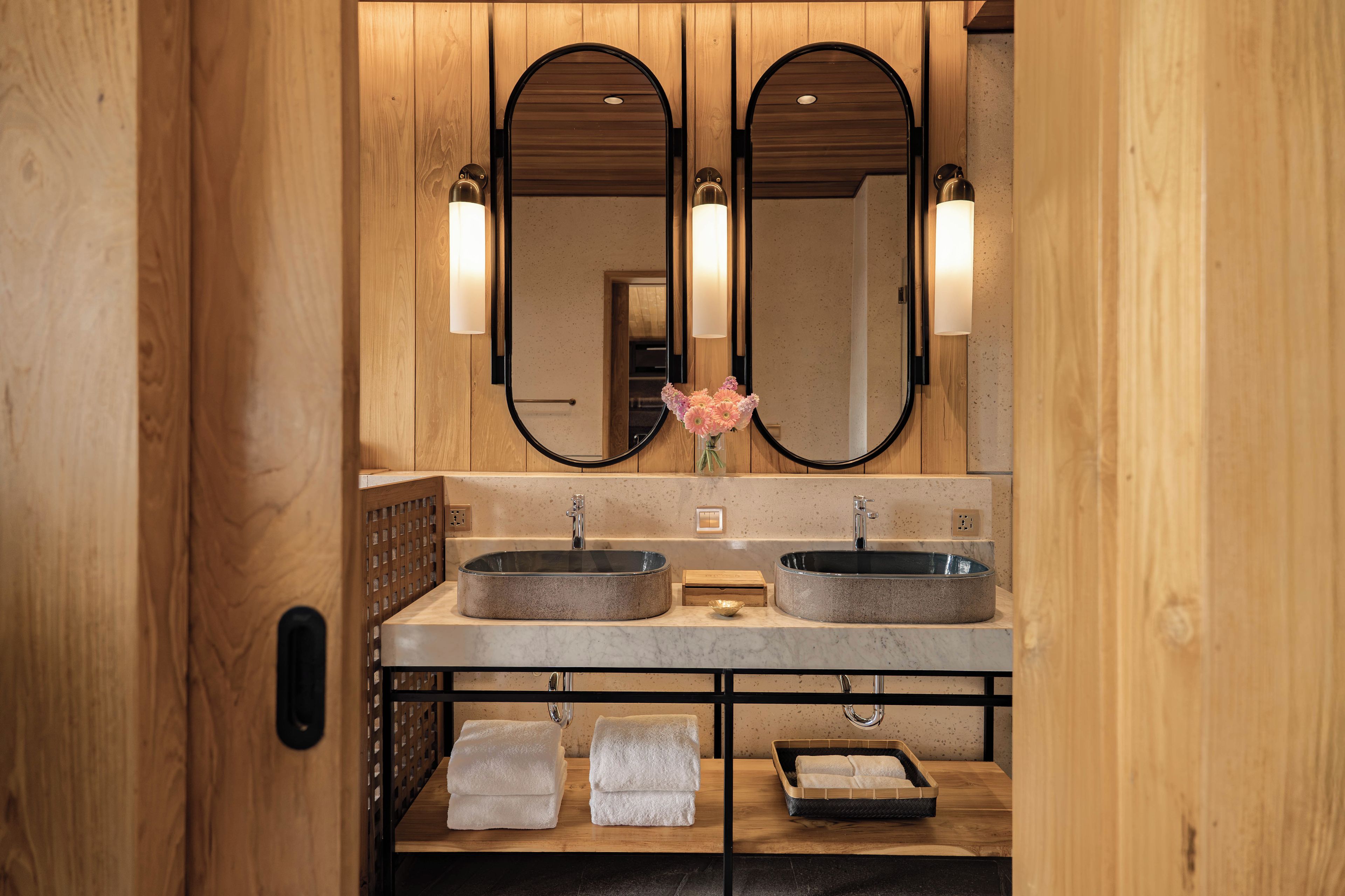 A bathroom with two sinks, a mirror, and a wooden vanity.