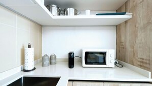 Une cuisine équipée d’un four à micro-ondes, d’une machine à café et de deux récipients étiquetés « CUISINE » et « CHEF ».