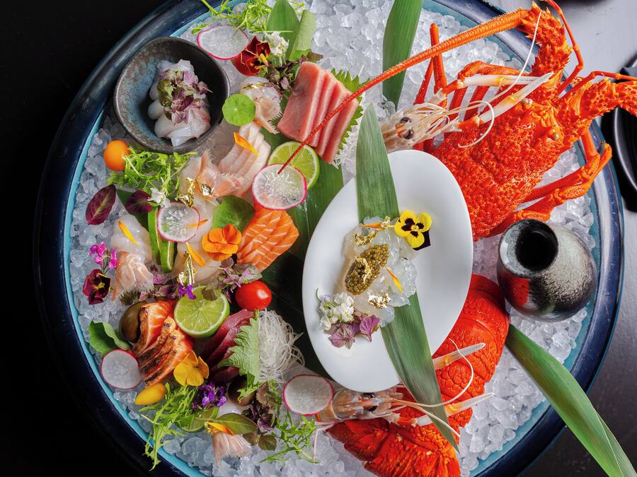 Eine Platte mit Meeresfrüchten, verschiedenen Fischsorten und Beilagen auf einer Eisschicht.