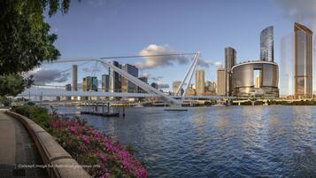 A waterfront cityscape with modern architecture, including a distinctive bridge and high-rise buildings.