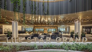 Un intérieur d’hôtel moderne, agrémenté d’une grande enseigne sur laquelle on peut lire : « THE STAR GRAND ».