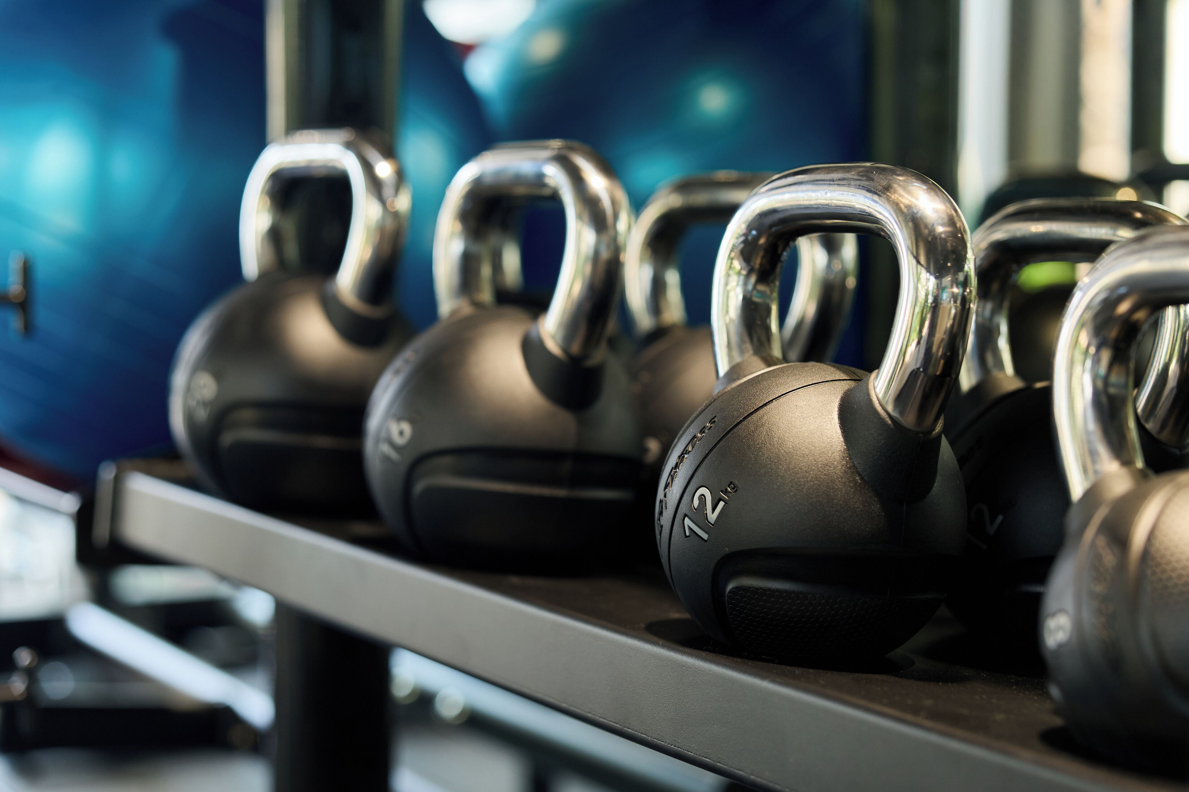 A rack of kettlebells with weights marked on them.