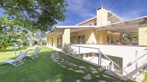 A modern house with a covered patio, a stone staircase, and a lawn with lounge chairs. - Villa Reginella - Reginella Deluxe (Lecce)