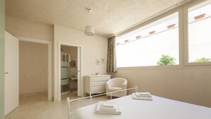 A bedroom with a bed, a desk, a chair, a window, and a shower. - Villa Reginella - Reginella Deluxe (Lecce)