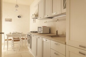Compact kitchen with a dining table and sink, perfect for preparing meals.