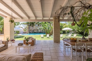An outdoor patio with a pool, lounge chairs, and a dining area.