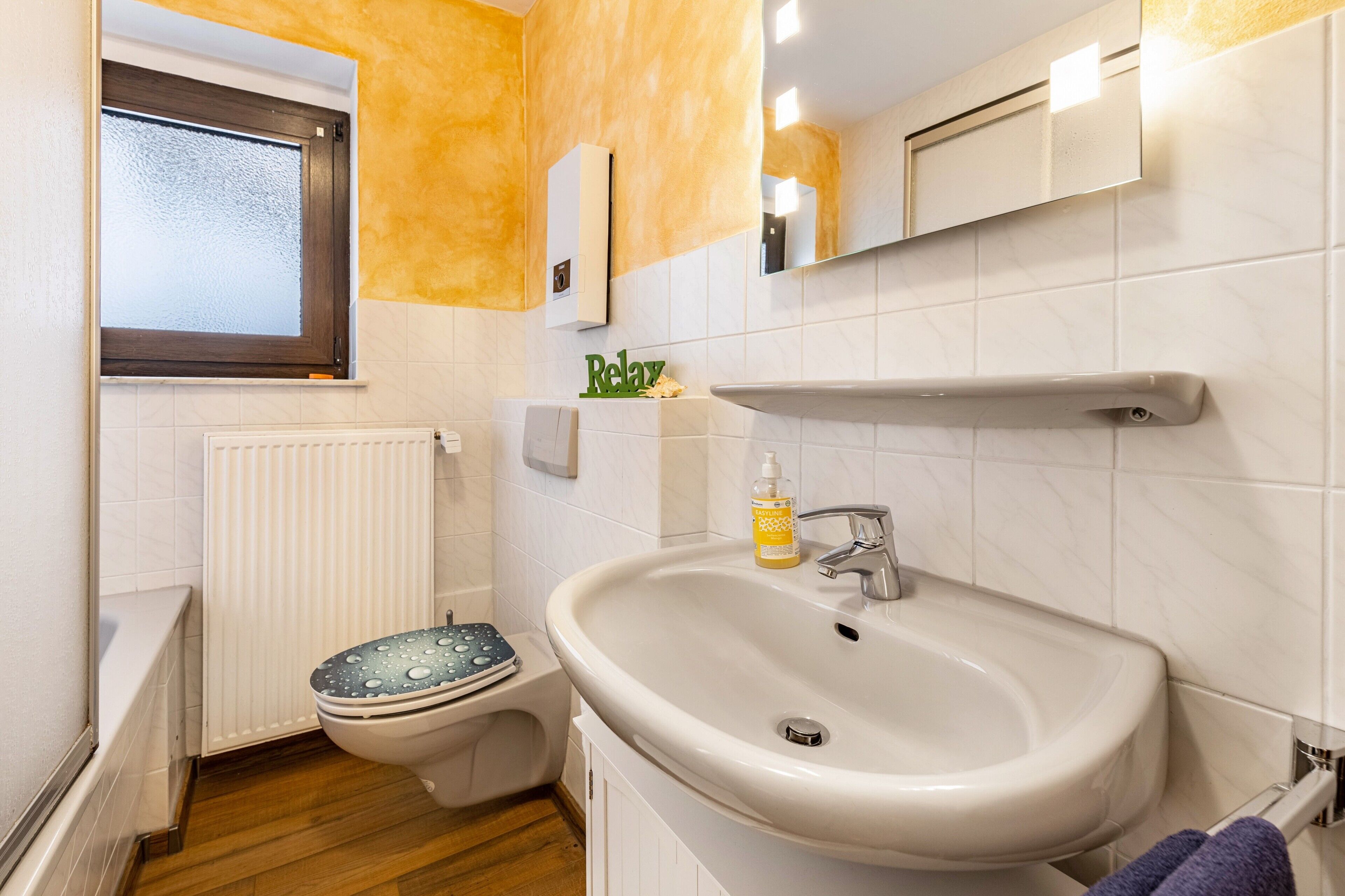 Ein Badezimmer mit Toilette, Waschbecken und Fenster.