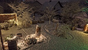 Ein mit Schnee bedeckter Garten mit einer hölzernen Bank, einem Steinpflanzgefäß und einem Metallfass.