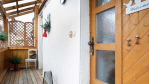 Eine Holztür mit einer Milchglasverkleidung und einem Schild mit der Aufschrift 'Welcome' darüber.