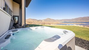 Ein Whirlpool mit Blick auf einen See und Berge.