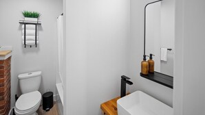 A modern bathroom with a toilet, sink, and shower. - Spacious Riverside Suite | Kitchenette, BBQ, Dock (Lake Cowichan)