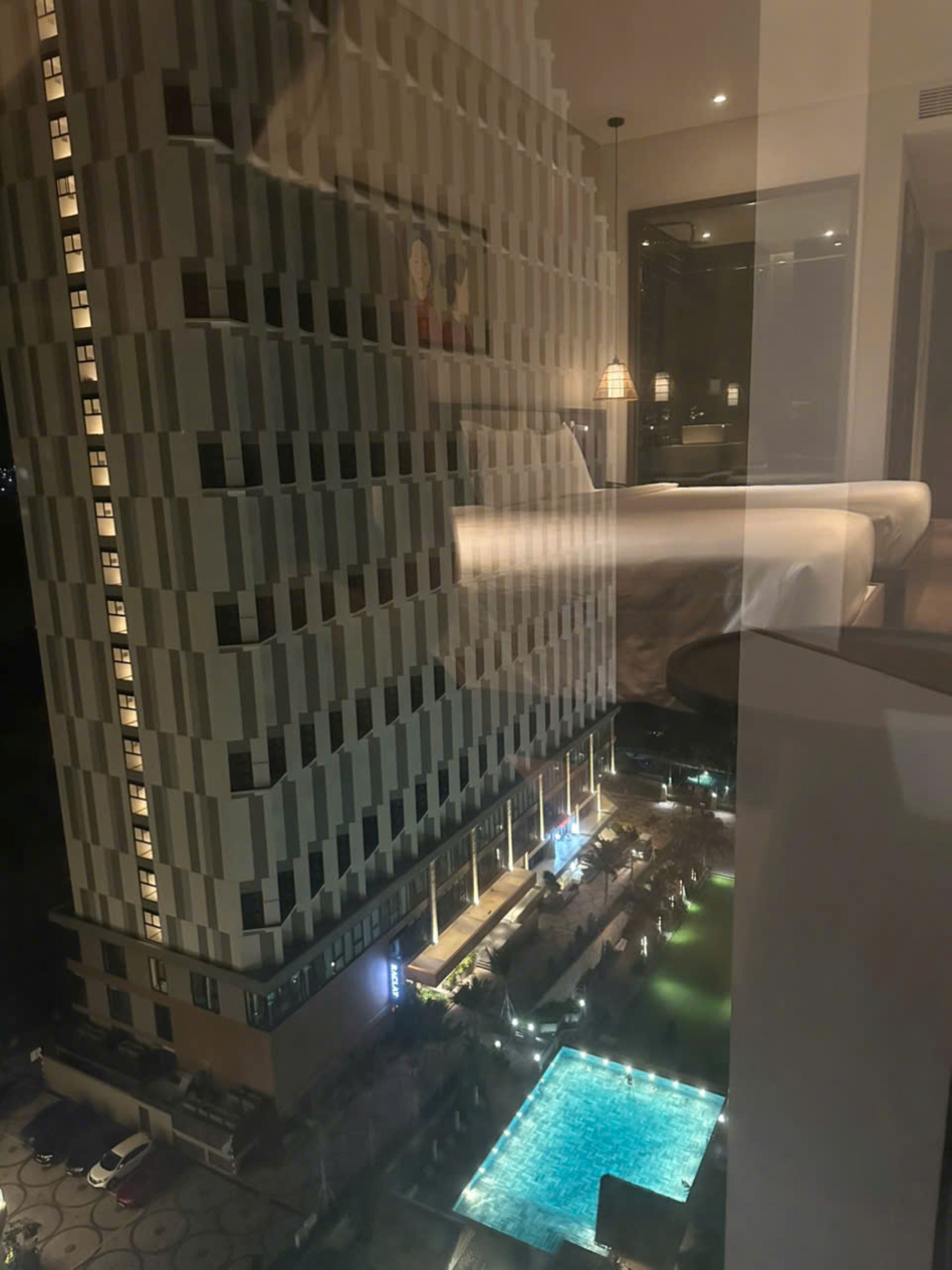 Ein Hochhaus mit einem darunter liegenden Poolbereich.