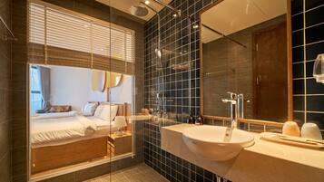 Un bagno moderno con un ampio specchio, due lavabi e una doccia.