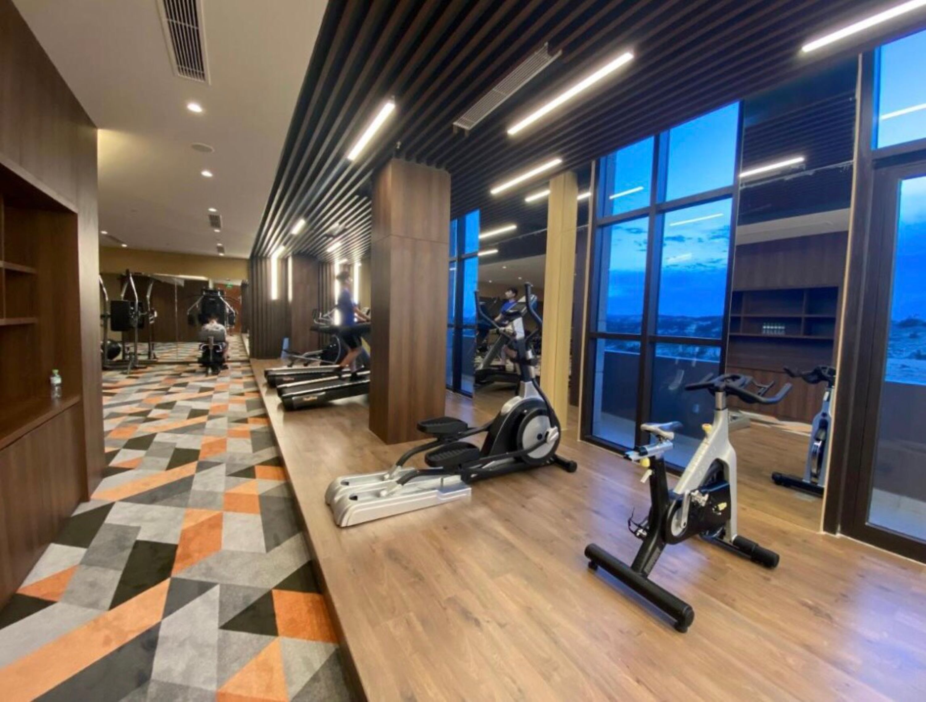 A gym with treadmills, stationary bikes, and exercise equipment.