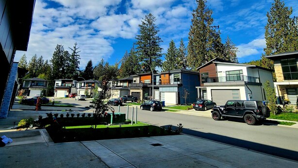 A modern residential area with contemporary houses, a clear sky, and a street with parked cars. - 1 - BR Travellers  Basement Suite.NO Cleaning fee, Sumas Mountain Rd,Abbotsford (Abbotsford)
