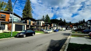 A modern residential street with contemporary houses, a clear sky, and parked cars. - 1 - BR Travellers  Basement Suite.NO Cleaning fee, Sumas Mountain Rd,Abbotsford (Abbotsford)