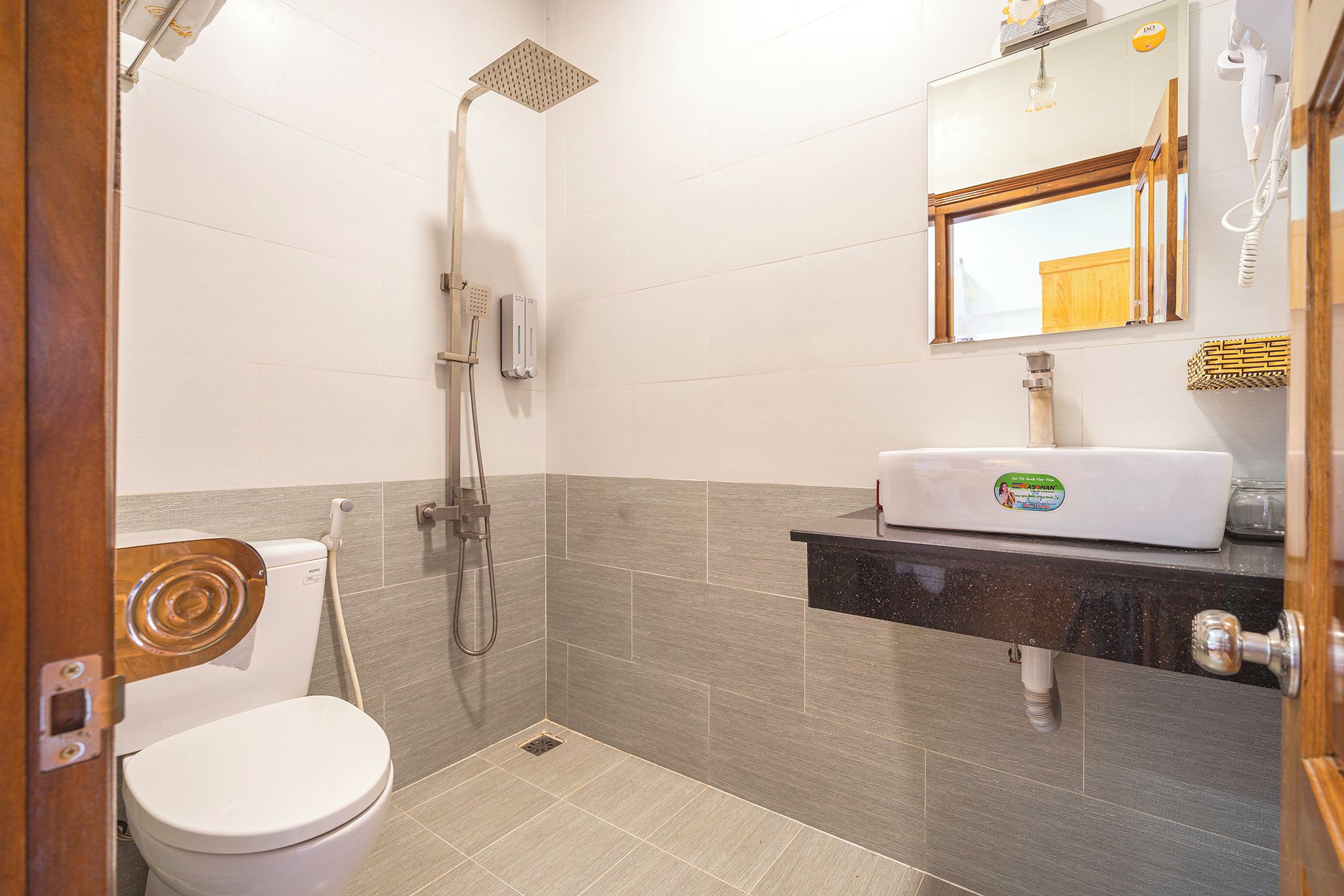 A compact bathroom with a toilet, a shower, and a sink.