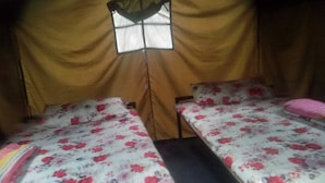 A tent-style room with two beds, each with floral bedding. - Sukute Valley Resort (Kadambas)