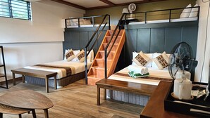 A hotel room with two beds, a wooden staircase, a fan, and a table with a tray. - Mist Mountain Resort powered by Cocotel (Cebu City)