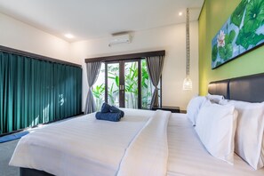 A hotel room with a large bed, a view of greenery through the window, and a painting of flowers on the wall. - 888 Residence Villa with Private Pool (Ubud)