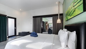 Camera d'albergo moderna con un letto grande, una scrivania e vista sul corridoio.