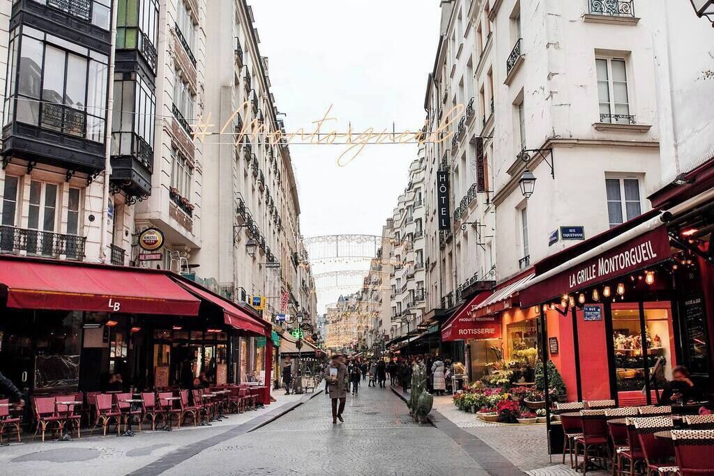 A street lined with cafes and shops, including a visible restaurant named "La Grille Montorgueil" and a hotel named "HOTEL".