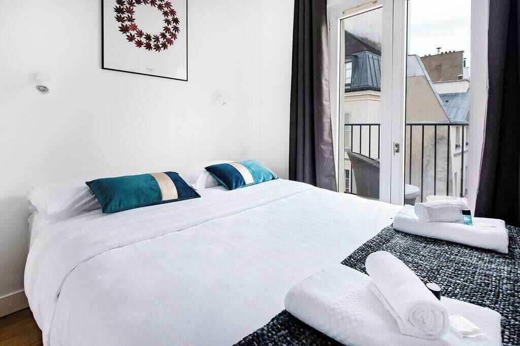 Une chambre d’hôtel avec un lit, des oreillers, une serviette et une vue sur l’extérieur.