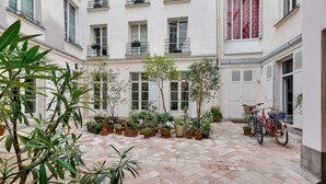 A courtyard with potted plants and a bicycle.