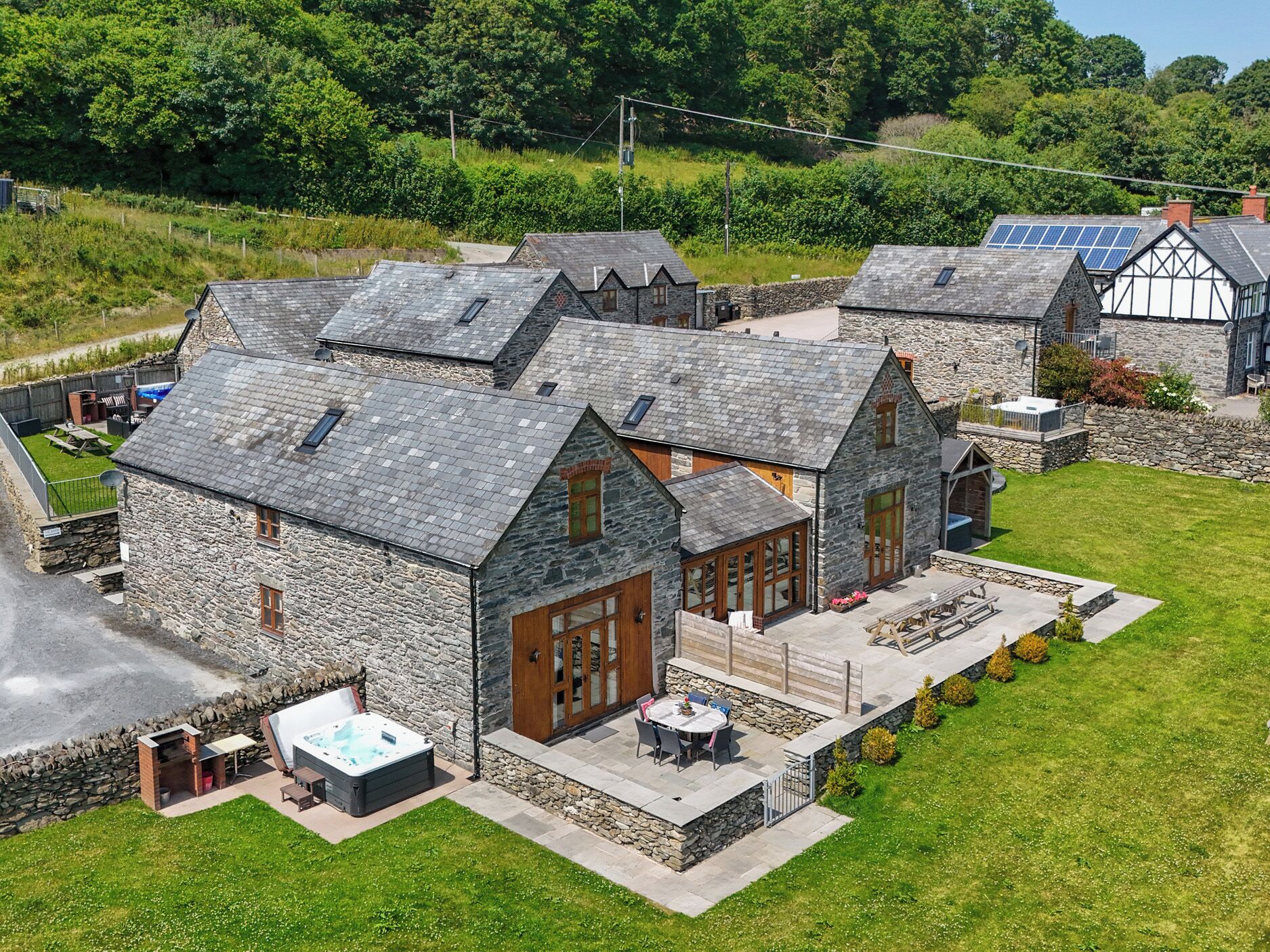 A stone building with a patio area, a hot tub, and a view of the surrounding landscape.