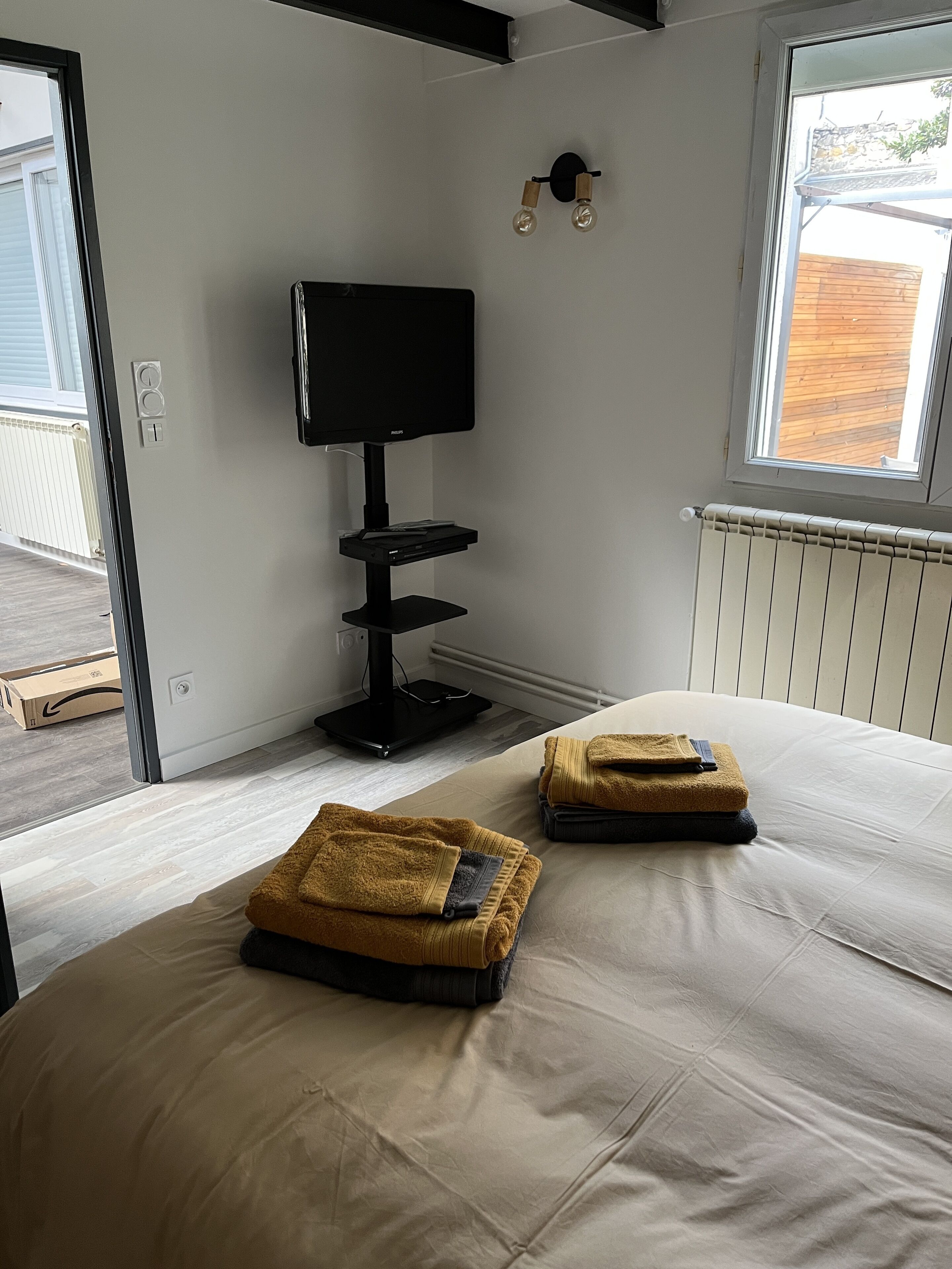 Habitación de hotel moderna con una cama grande, un televisor de pantalla plana y una ventana con vistas al exterior.