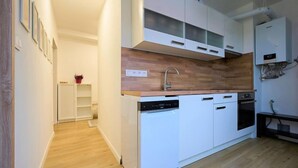 A modern kitchen with white cabinetry, a wooden countertop, and a dishwasher. - Harrachov 377 by Interhome (Harrachov)