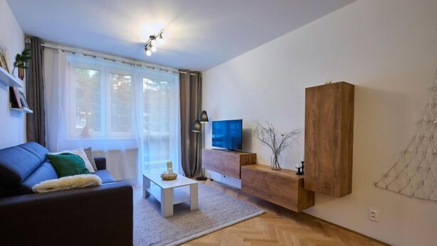 A modern living room with a sofa, a coffee table, a TV, and a wooden cabinet. - Harrachov 377 by Interhome (Harrachov)