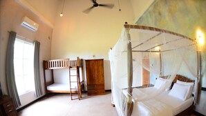 A bedroom with a four-poster bed, a bunk bed, a wooden wardrobe, and a ceiling fan.